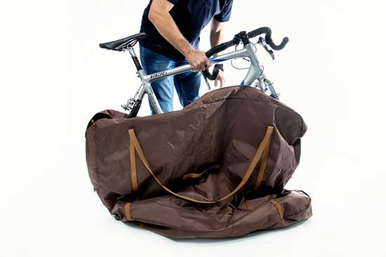 a male individual packing a bicycle into a bag