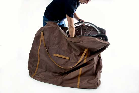 a male individual packing a bicycle into a bag